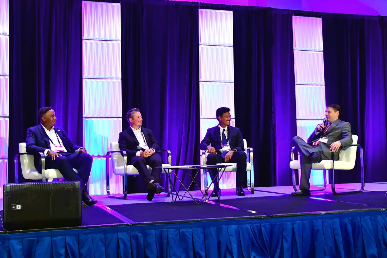 Four panelists seated on stage during an AI panel discussion, September 2025